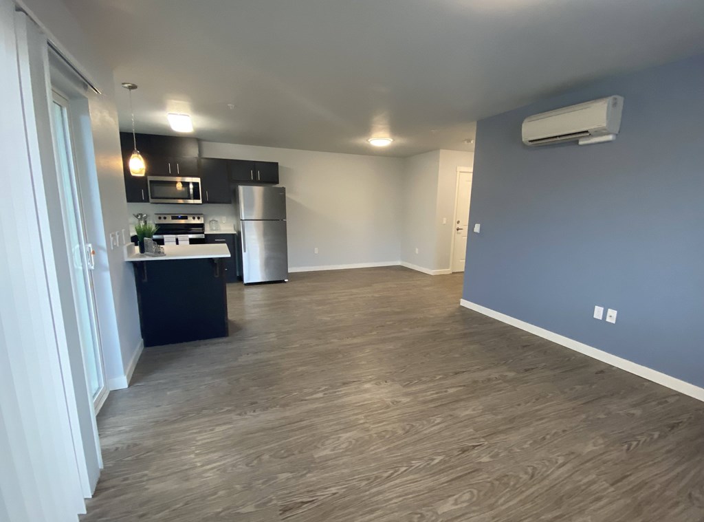 A kitchen area with a stainless steel refrigerator and a microwave.