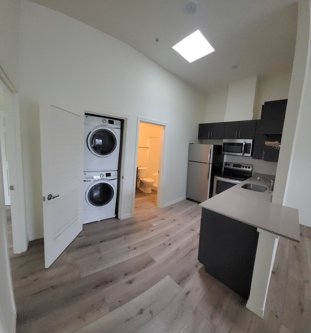 A kitchen with a washer and dryer in the laundry room. Clark Apartments Vancouver WA