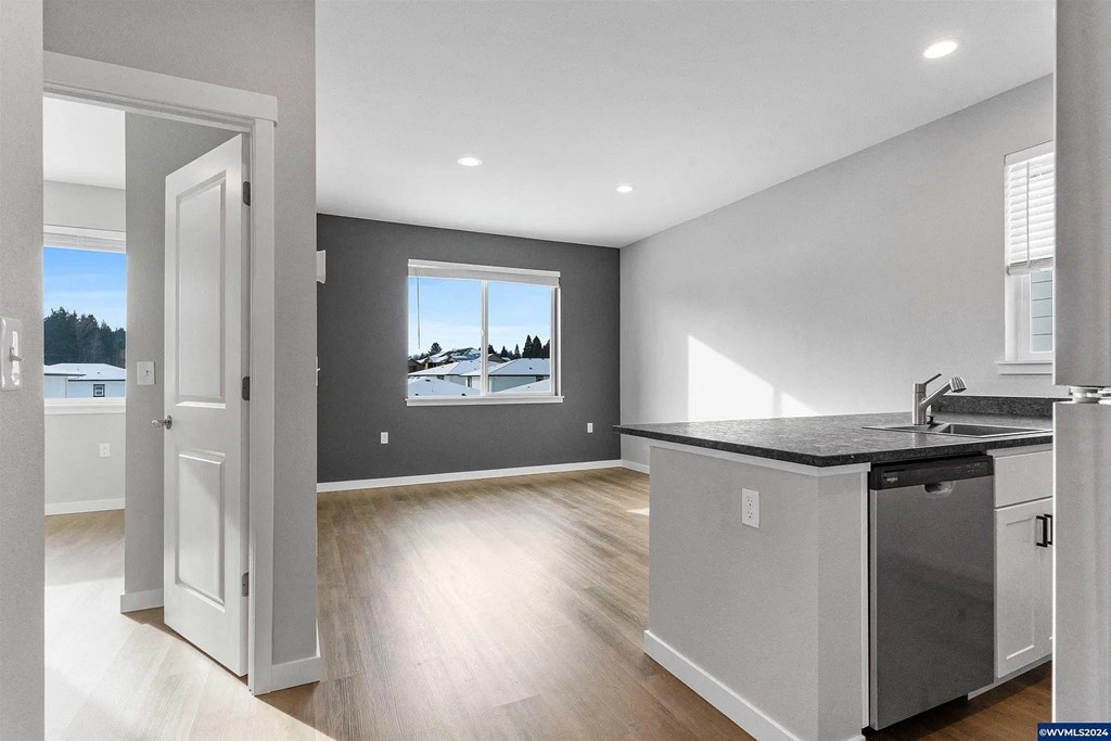 A kitchen with a black countertop and stainless steel appliances.