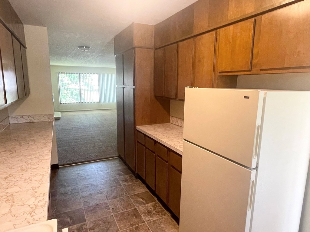 Metro Park Terrace kitchen with wooden cabinets and a white refrigerator
