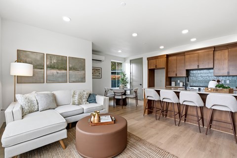 A modern living room with a white sofa and a brown coffee table.