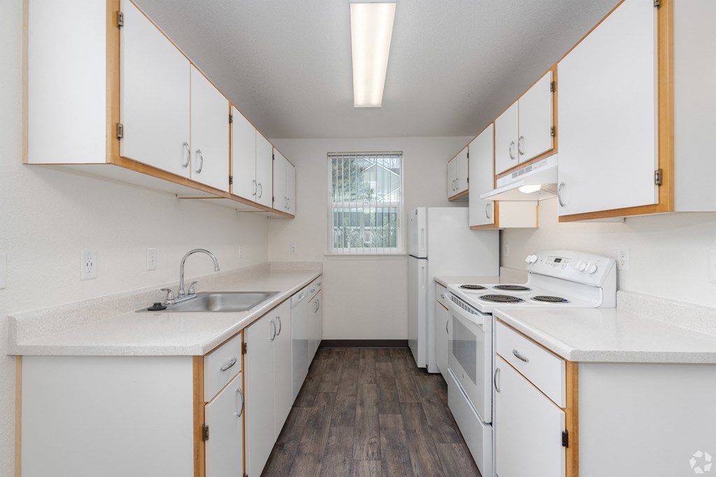 A kitchen with white cabinets and appliances.