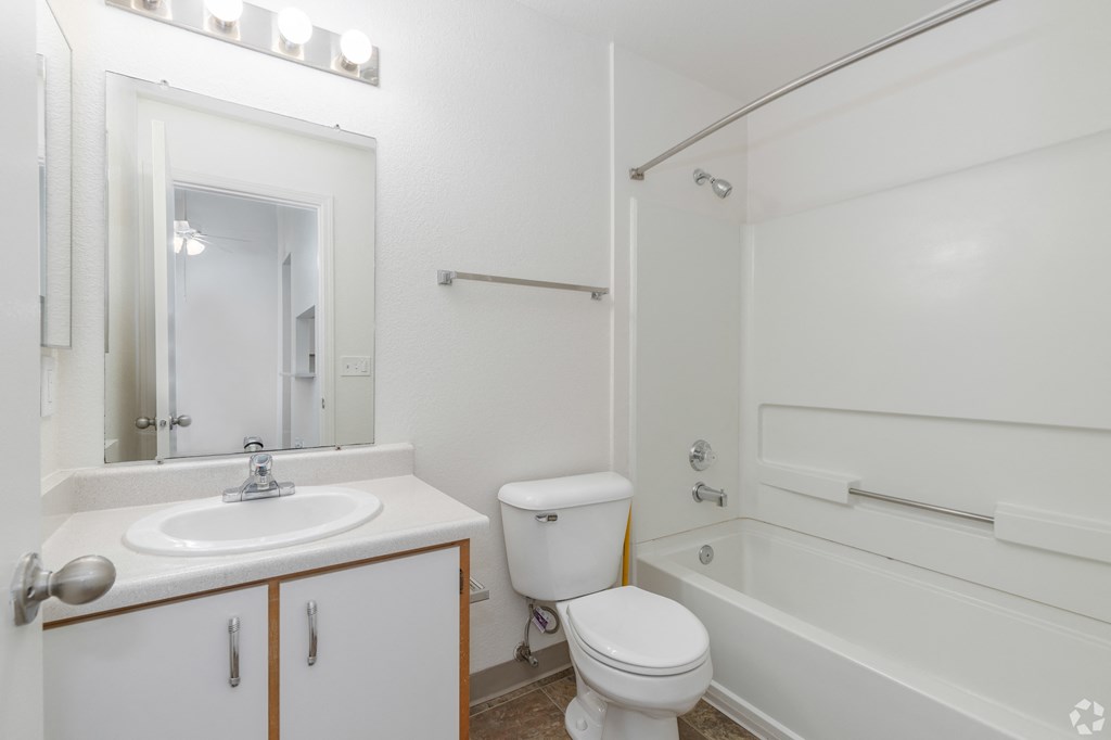 A white bathroom with a sink, toilet and bathtub.