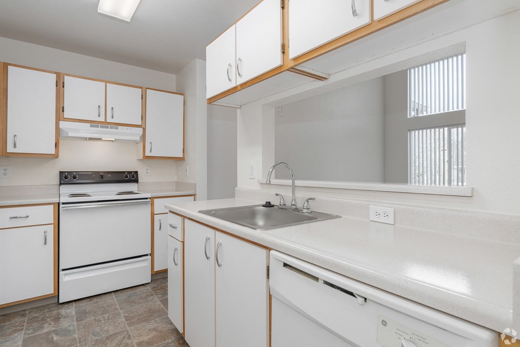 A kitchen with white appliances and wooden cabinets.