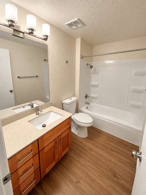 A bathroom with a sink, toilet, and bathtub.