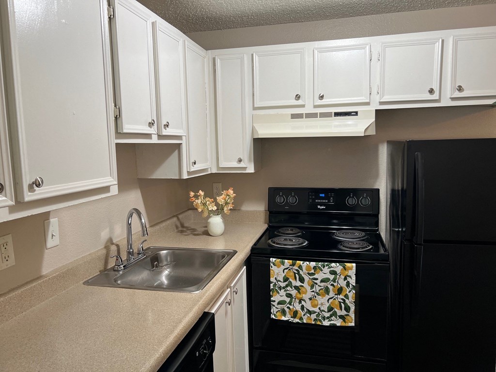 a kitchen with black appliances and white cabinets