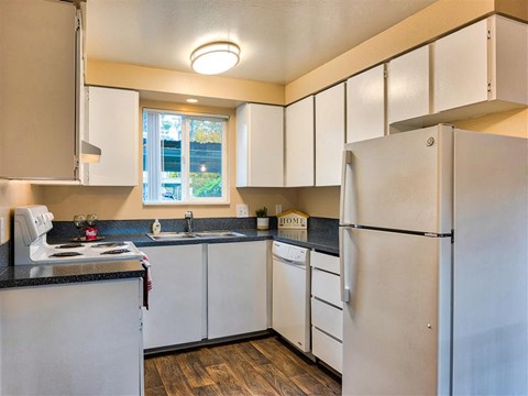 a kitchen with white cabinets and a refrigerator