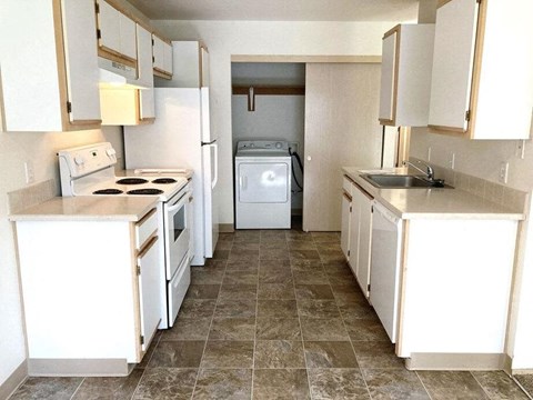 a kitchen with white cabinets and a stove and a sink
