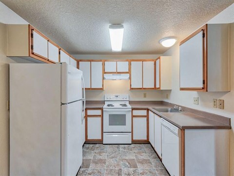 a kitchen with white appliances and wooden cabinets