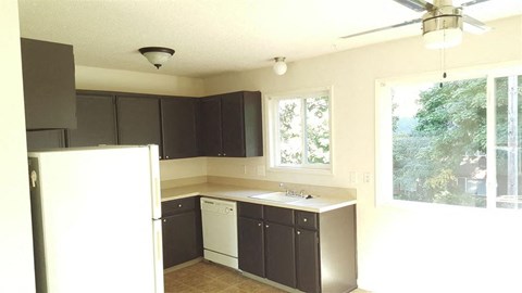 a kitchen with black cabinets and a white refrigerator
