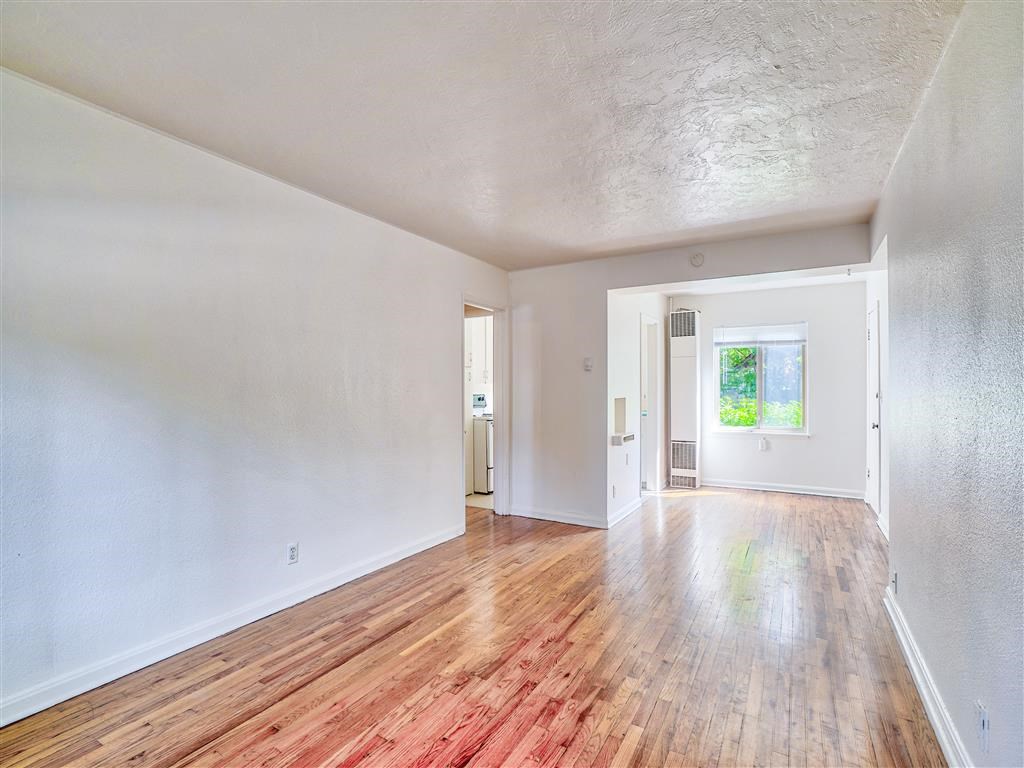 an empty living room with a hard wood floor