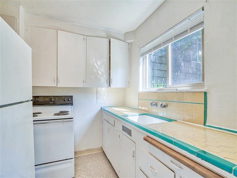 a kitchen with white appliances and white cabinets