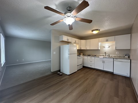 A kitchen with white cabinets and a white refrigerator.