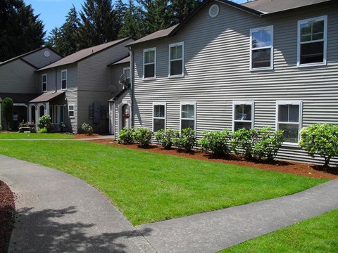 A building with a grey siding and a brown roof.