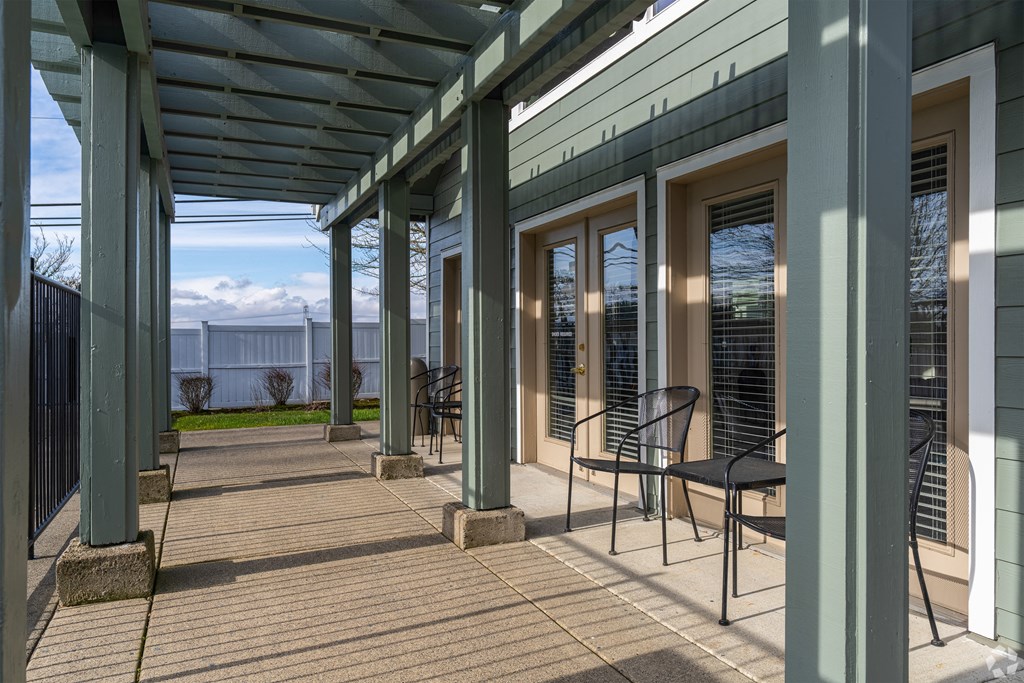 A patio with a roof and chairs.