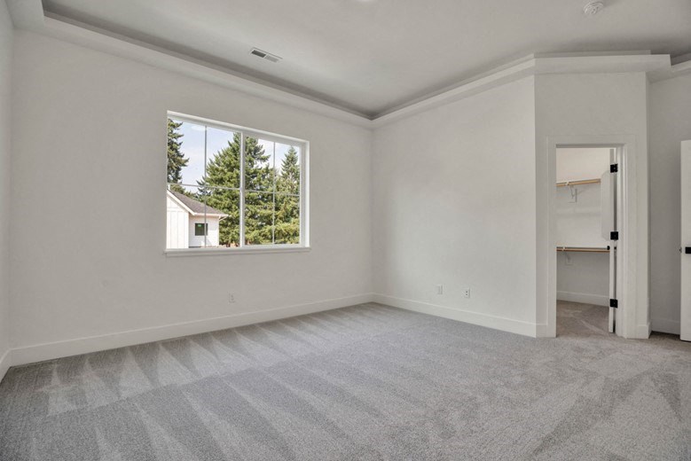 the living room of an empty house with a large window