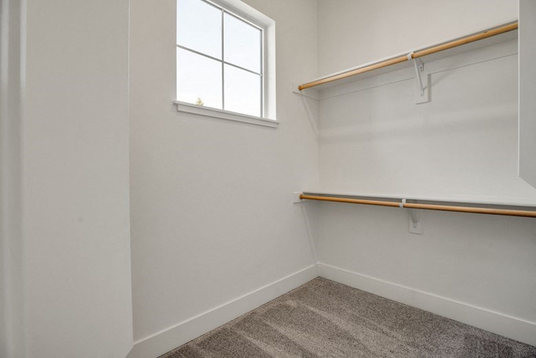 an empty room with a window and a white wall