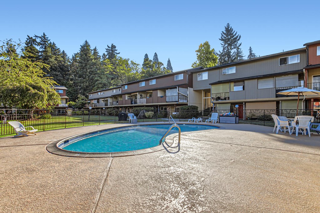 a swimming pool at a hotel with a building in the background