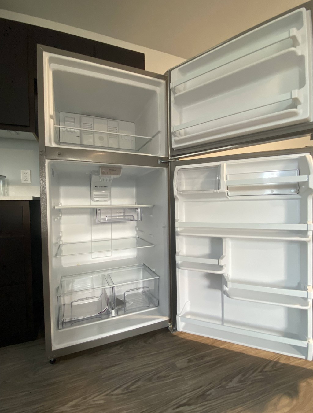 A white refrigerator with its door open in a kitchen.