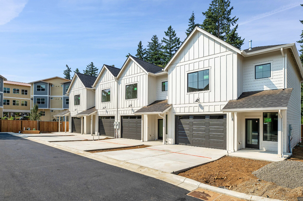 a row of houses with garage doors and a street