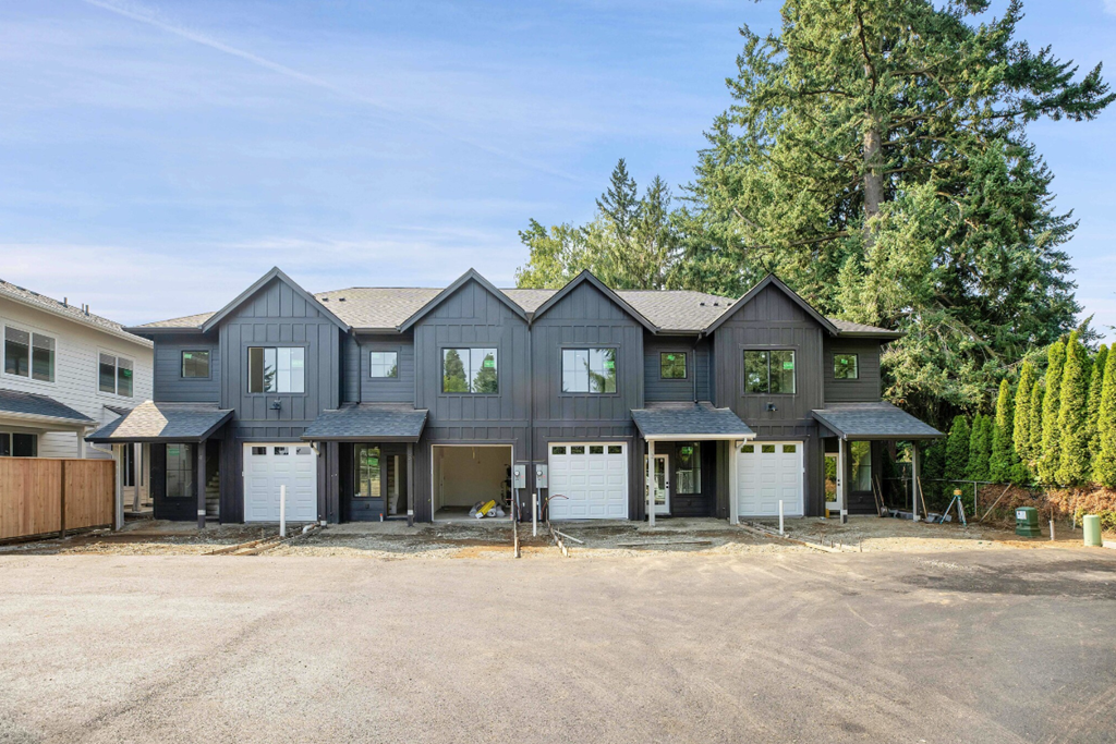 the front of a house with three garage doors and a driveway