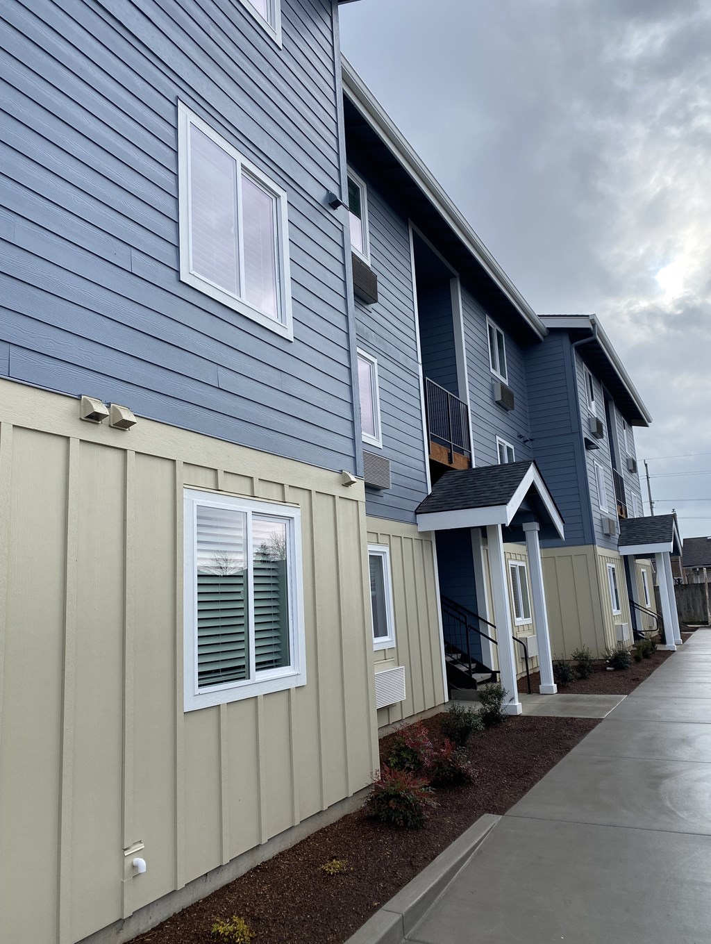 A row of houses with blue and beige siding.