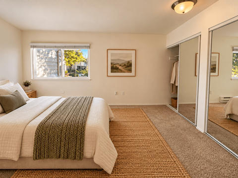 A bedroom with a large bed and a carpeted floor.