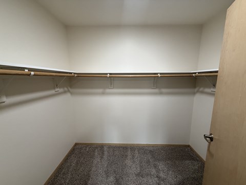 A small, empty room with a carpeted floor and a door on the right.