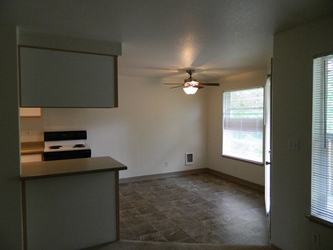 A kitchen with a stove top oven and a fan on the ceiling.