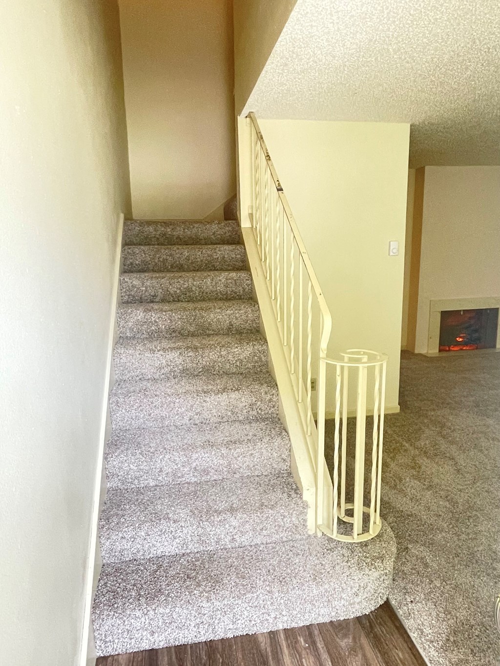 a view from the top of the stairs looking down into the living room