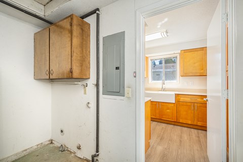 A room with a white wall and a wooden cabinet.