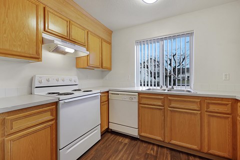 A kitchen with wooden cabinets and white appliances.