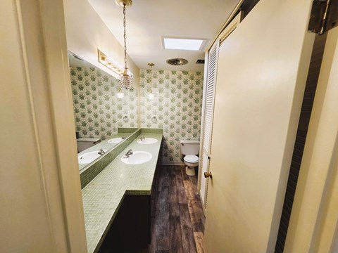 A bathroom with green tiles and a green sink.