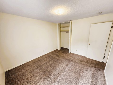 A room with a carpeted floor and a white door.
