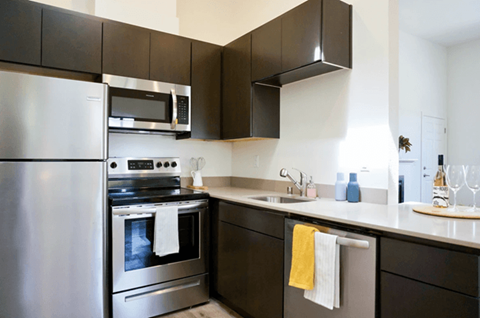 A modern kitchen with a stainless steel refrigerator and oven.
