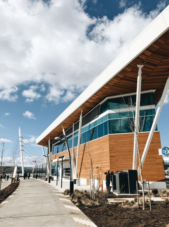 A modern building with a wooden exterior and glass windows. Clark Apartments Vancouver WA