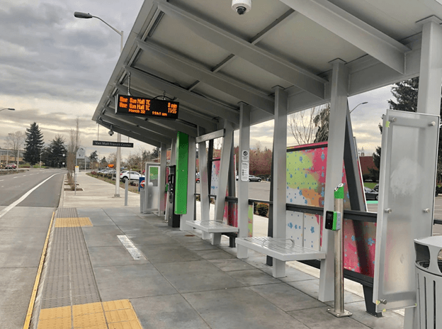 A bus stop with a digital display showing the bus number 101.