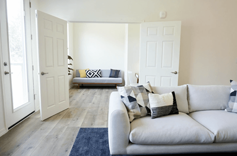 A living room with a couch and a blue rug.