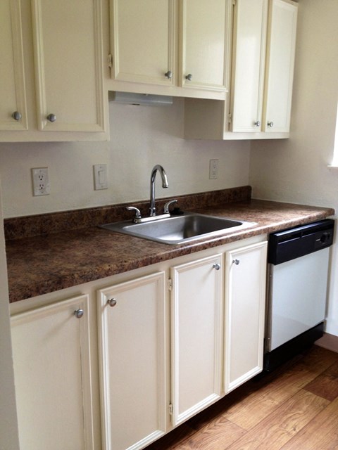 a kitchen with white cabinets and a sink and a counter