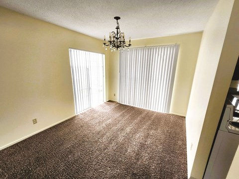 A room with a chandelier and a carpeted floor.