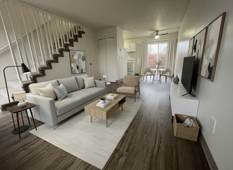 A living room with a grey couch and a wooden floor.