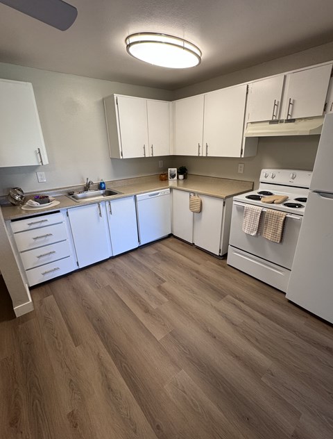 A kitchen with white cabinets and a white refrigerator.