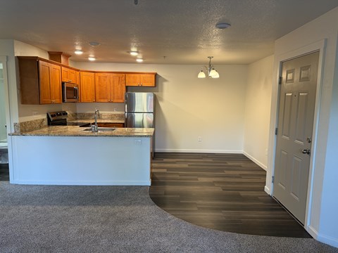 A kitchen with a white counter top and wooden cabinets.