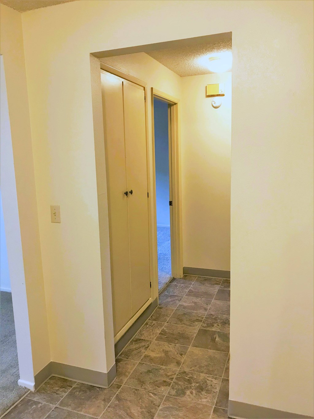 Nell Anna Court hallway with a blue door and tiled floor.