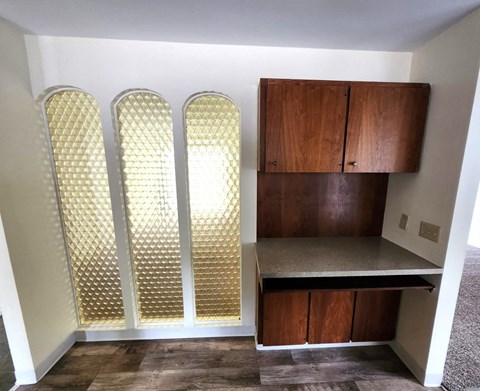 A room with a wooden cabinet and a shelf.