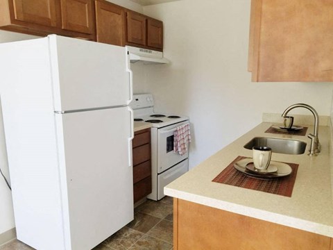 A kitchen with a white refrigerator, stove, and oven.