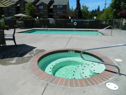 A hot tub sits in the middle of a pool area.