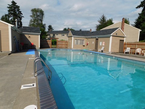 a large pool with a fence around it in front of a building