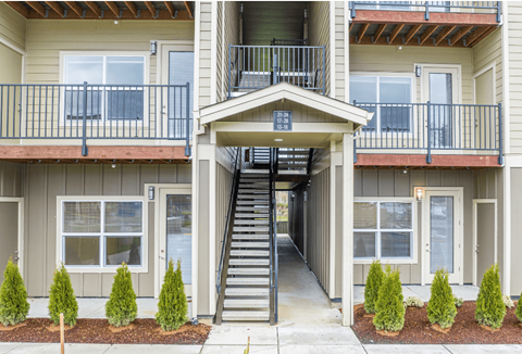 A two-story apartment building with a staircase leading to the second floor.