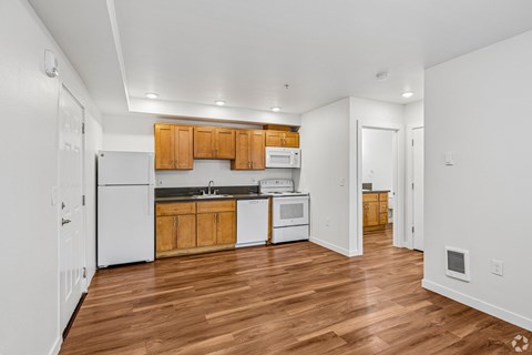 A kitchen with wooden floors and white walls.